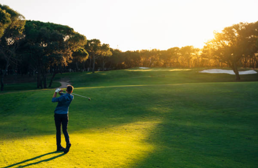 A golfer approaching a well-maintained green